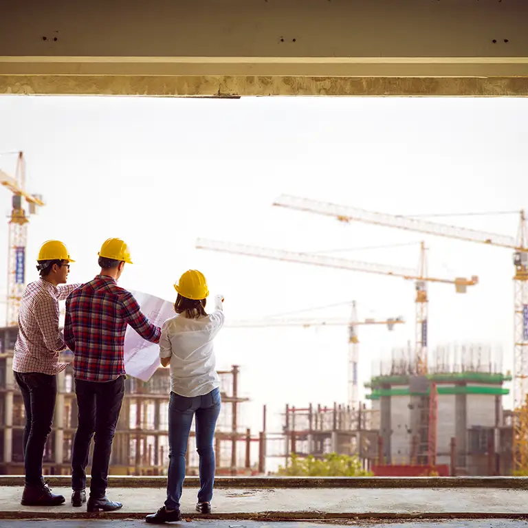 Construction team reviewing plans representing real estate and construction financial services.