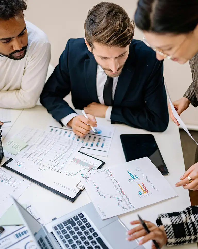 KG Financial Group diverse team collaborating on complex financial reports and data analysis.